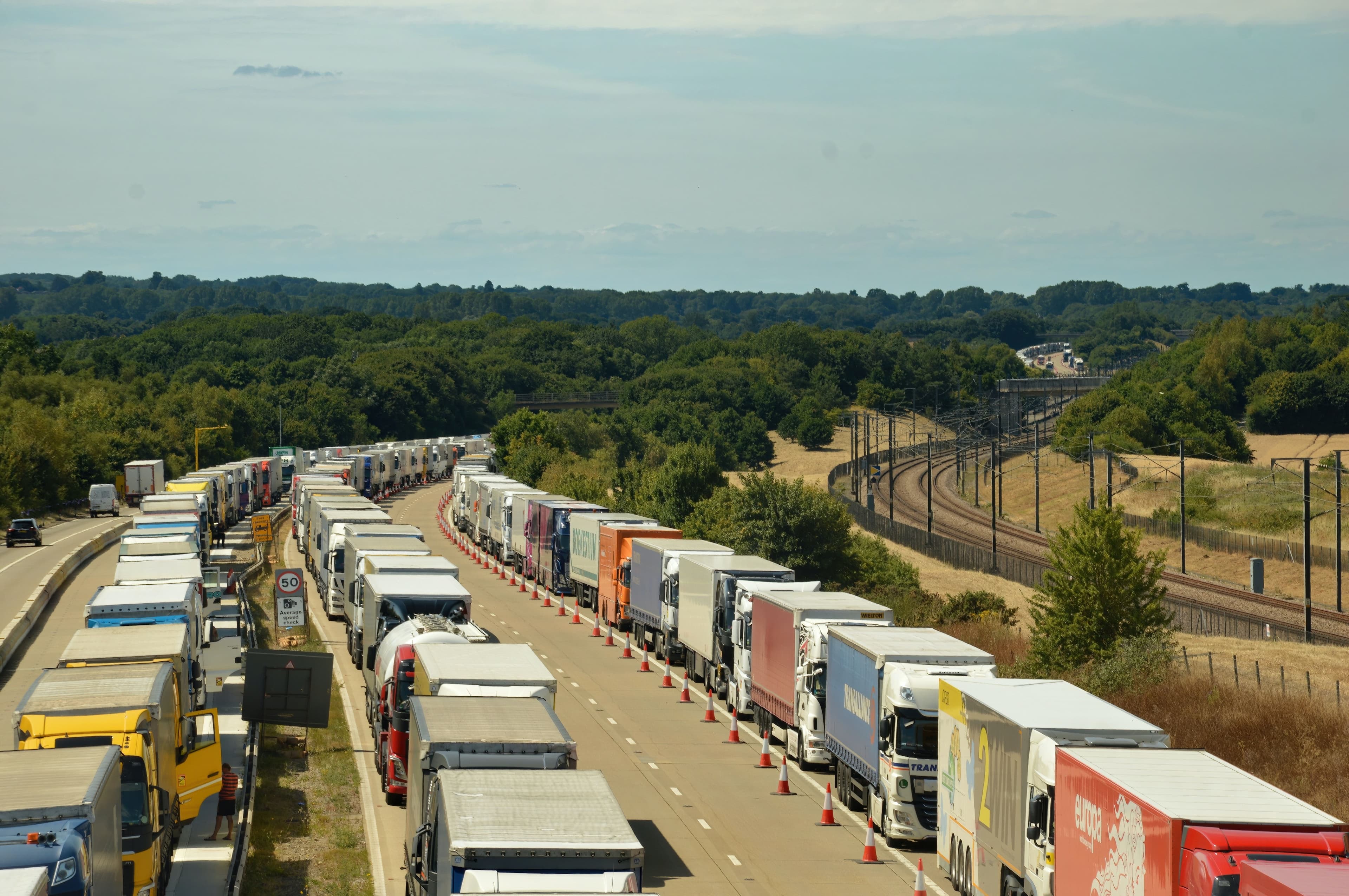 Traffic jam on a highway with a parallel railway track visible to the right.